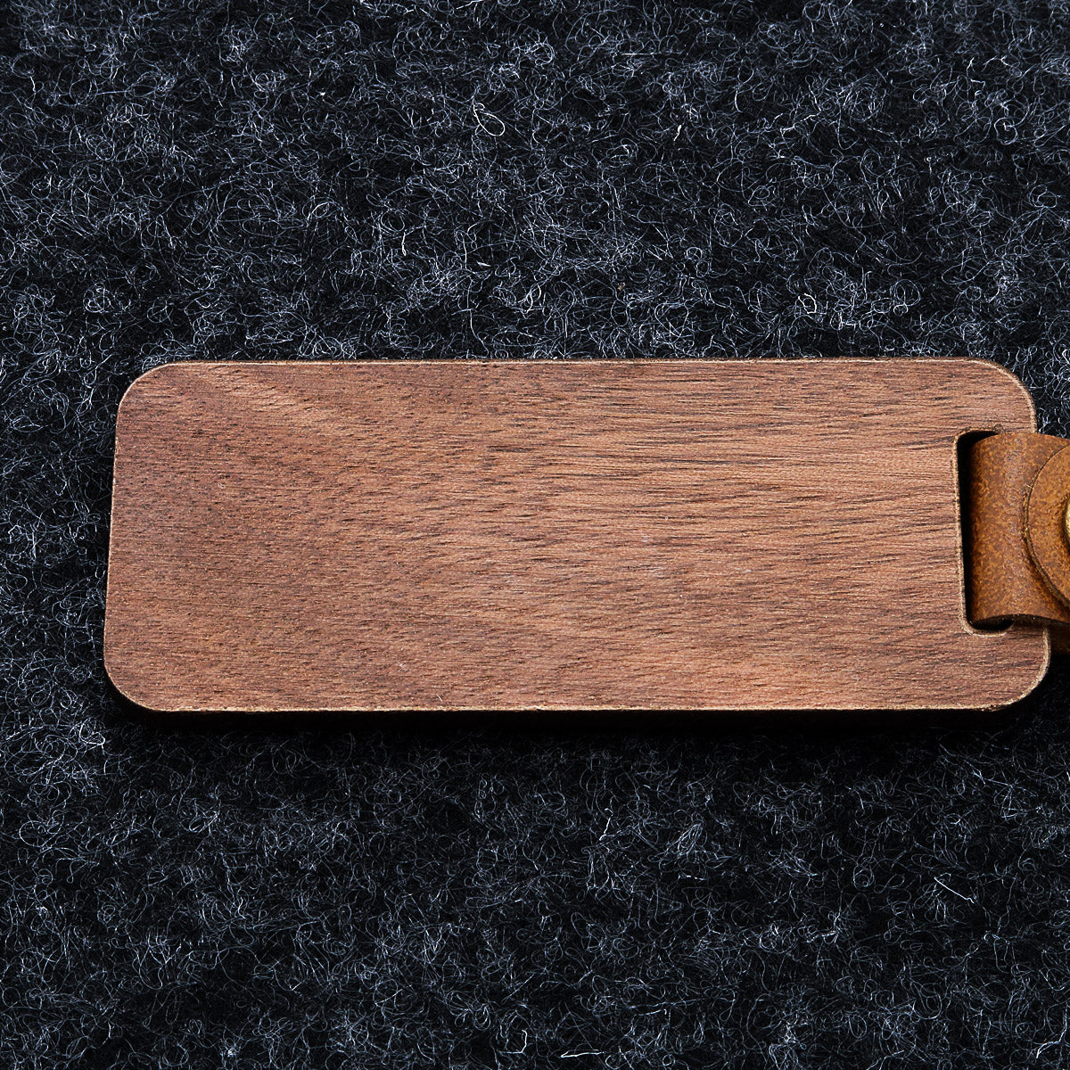 Personlig nøglering i træ med indgraveret ordsprog og krusedulle